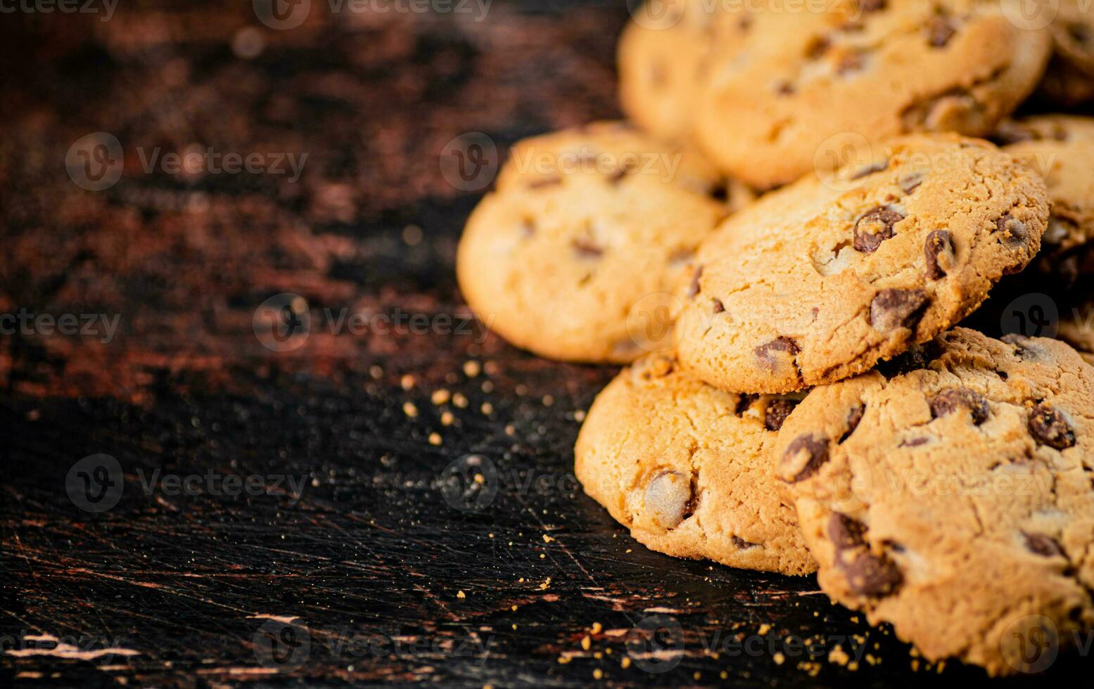 Cookies with pieces of milk chocolate on the table. photo