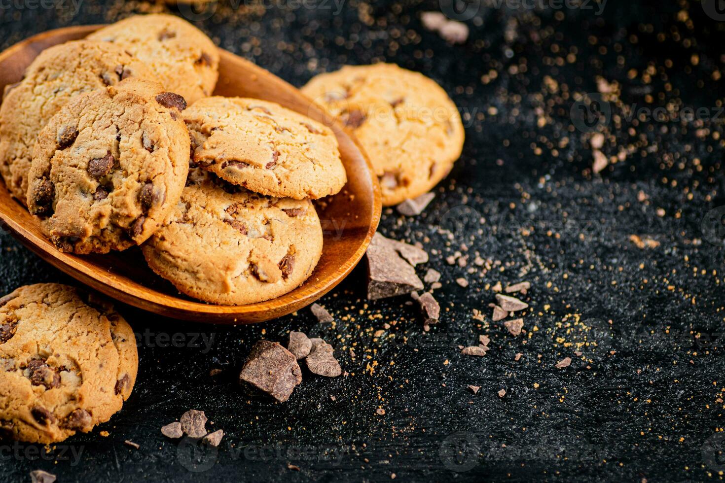 Wooden plate with cookies and pieces of milk chocolate. photo