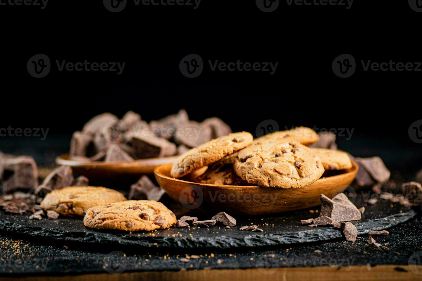 Cookies with pieces of milk chocolate on a stone board. photo