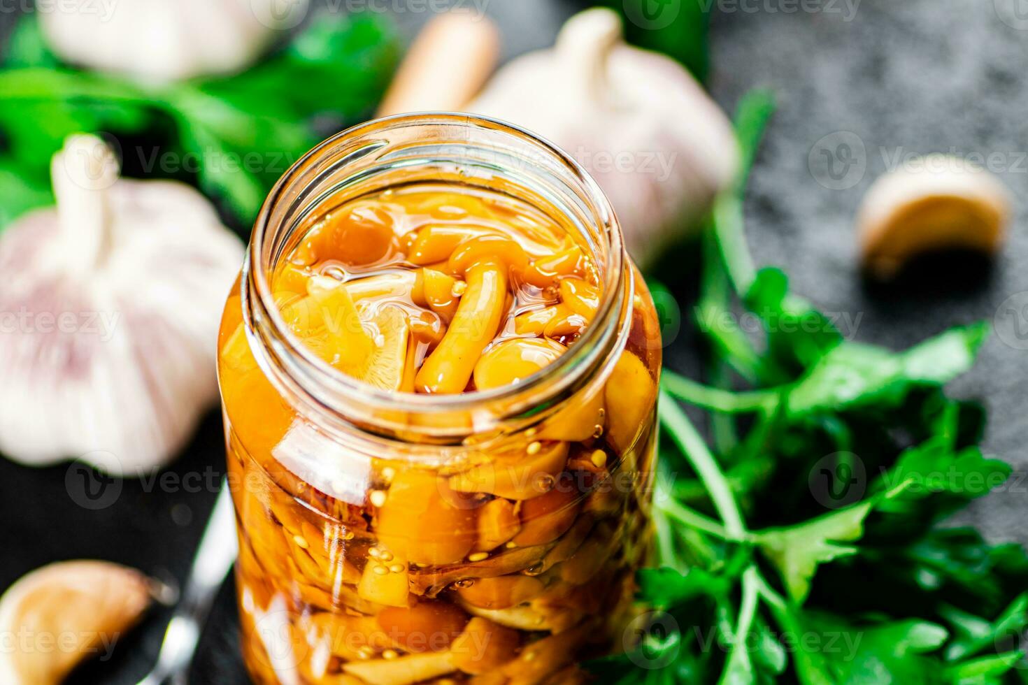 Marinated mushrooms with a glass jar with parsley and garlic. photo