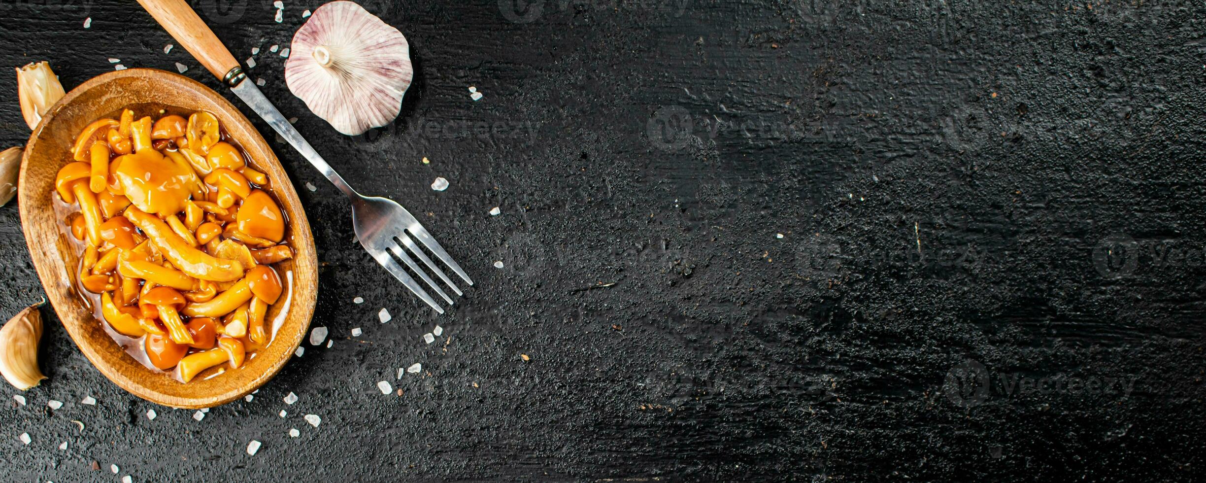 Marinated mushrooms on a plate with garlic and salt. photo