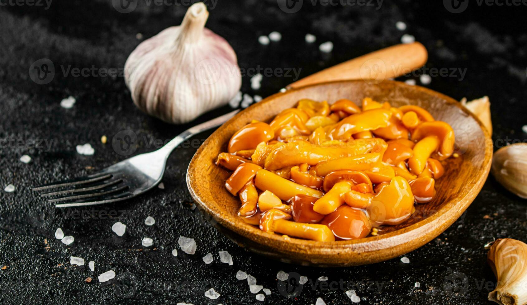 Marinated mushrooms on a plate with garlic and salt. photo