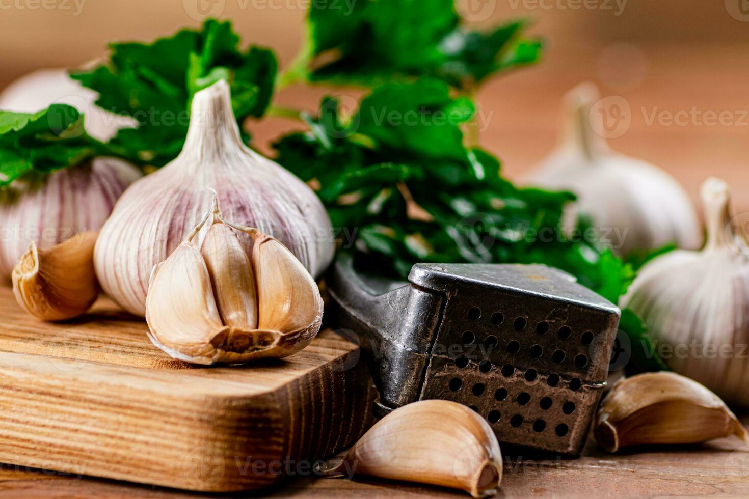 Garlic with parsley on a wooden cutting board. photo