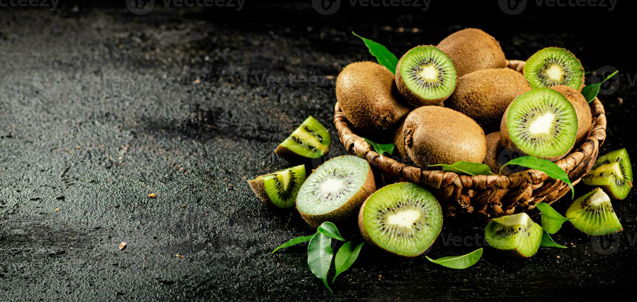 Fresco kiwi con hojas en un cesta. foto