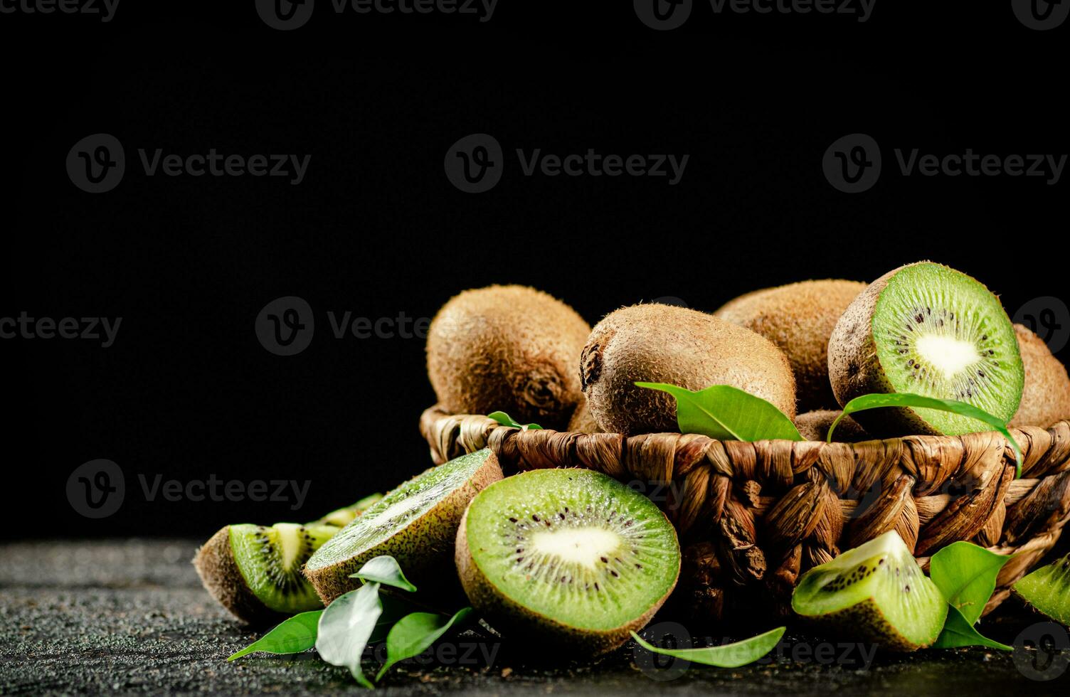 Fresh kiwi with leaves in a basket. photo