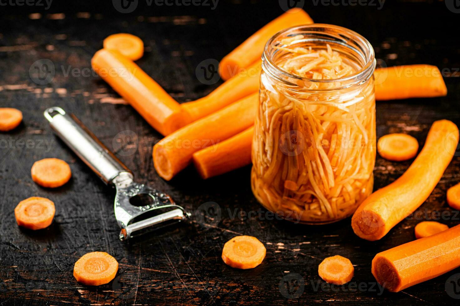Canned carrots in a glass jar on the table. photo