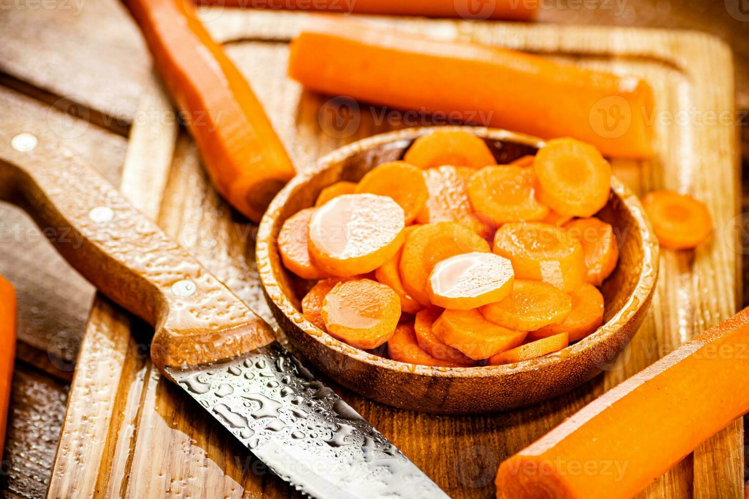 Sliced fresh carrots. On a wooden background. photo