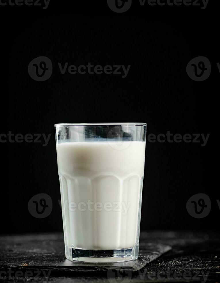 A glass of fresh milk on a stone board. photo