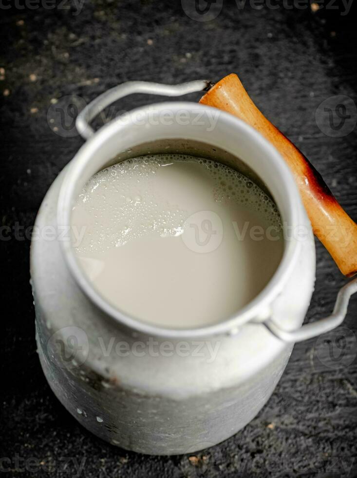 Fresh milk in a can on the table. photo