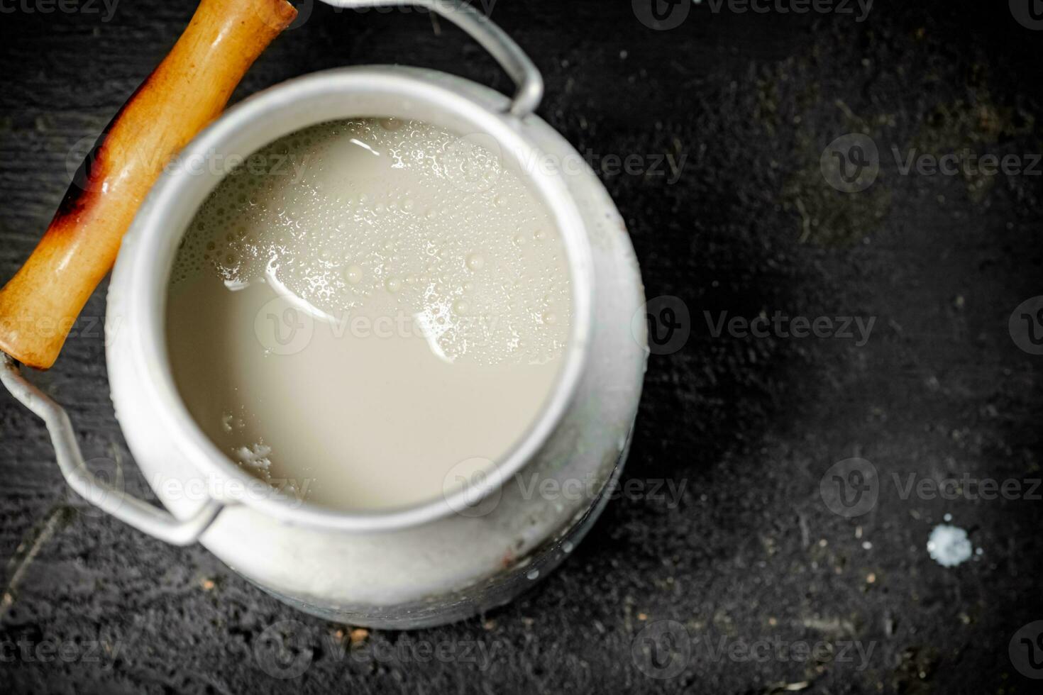 Fresh milk in a can on the table. photo