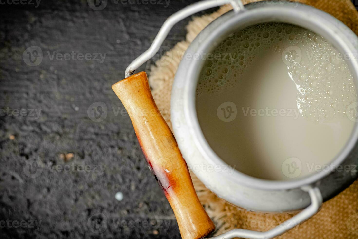 Fresh milk in a can on the table. photo
