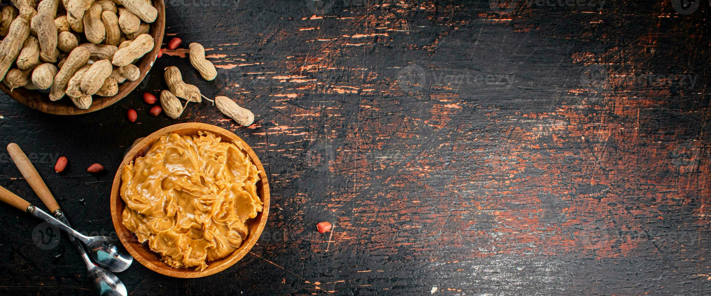 Peanut butter and inshell peanuts in wooden plates. photo