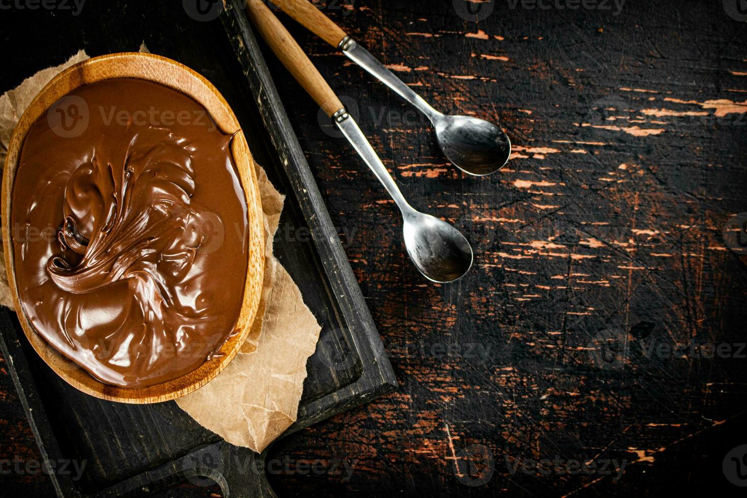 Hazelnut butter in a plate on a cutting board with paper. photo