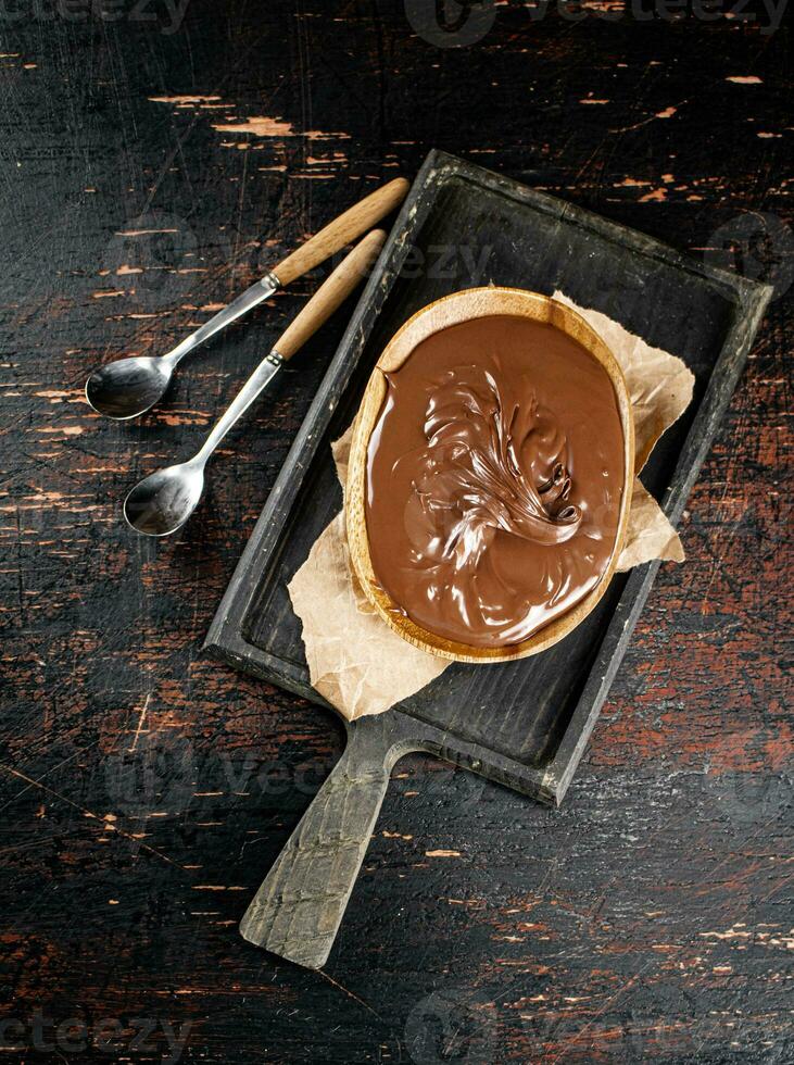 Hazelnut butter in a plate on a cutting board with paper. photo