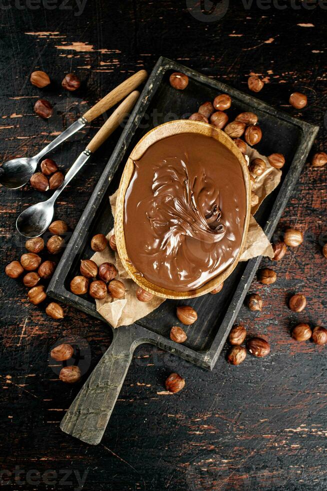 Hazelnut butter in a plate on a cutting board with paper. photo