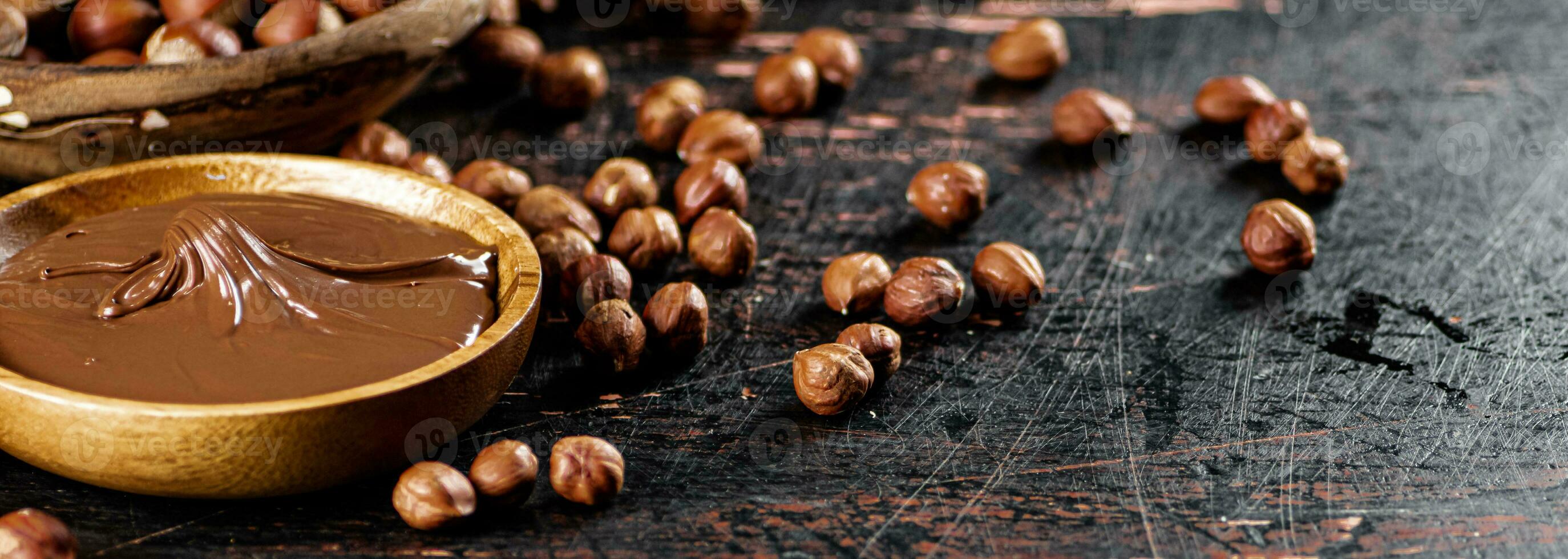 Hazelnut butter with peeled hazelnuts on the table. photo