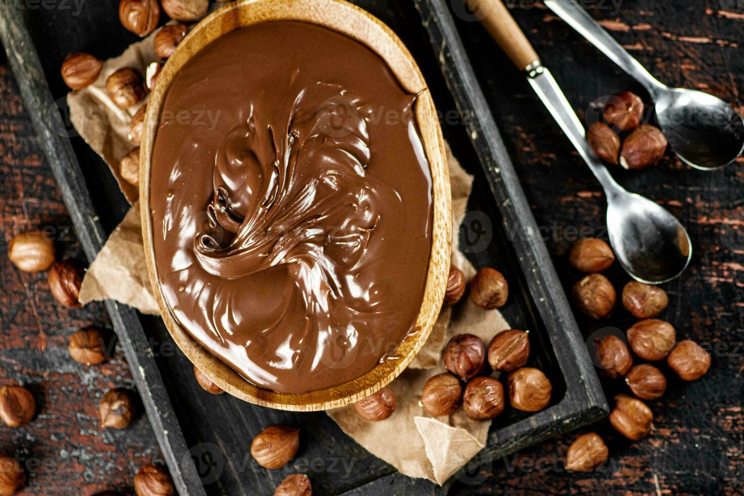 Hazelnut butter in a plate on a cutting board with paper. photo