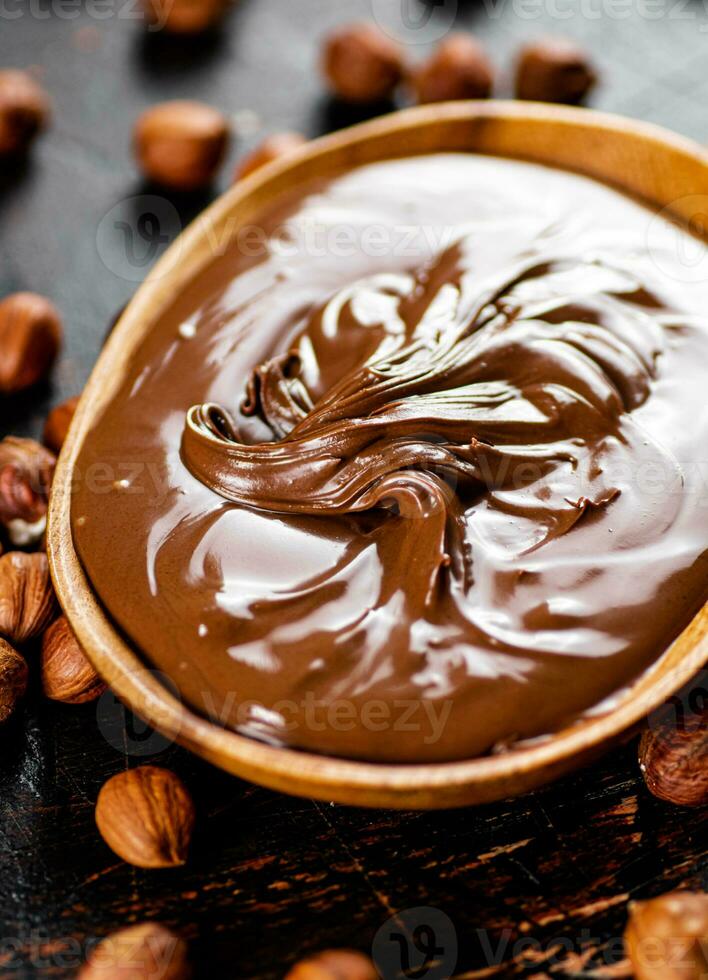 Hazelnut butter with peeled hazelnuts on the table. photo
