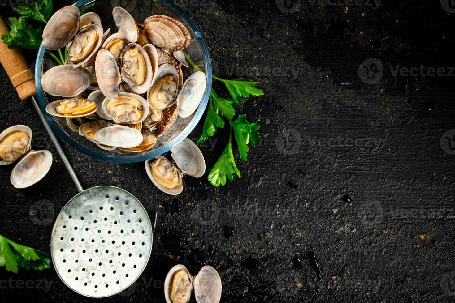 Fresh vongole in a glass bowl with parsley. photo