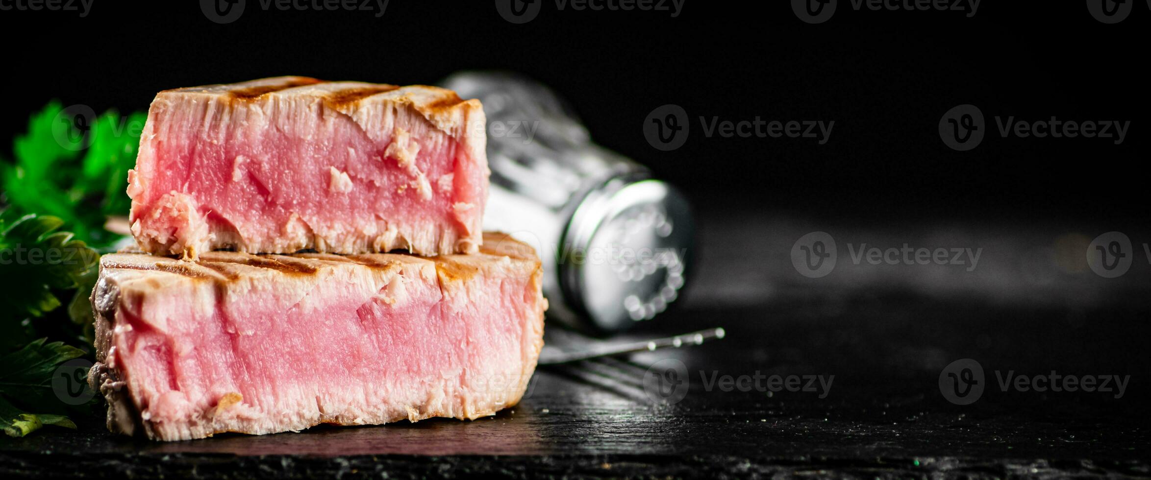 A piece of grilled tuna with parsley. photo
