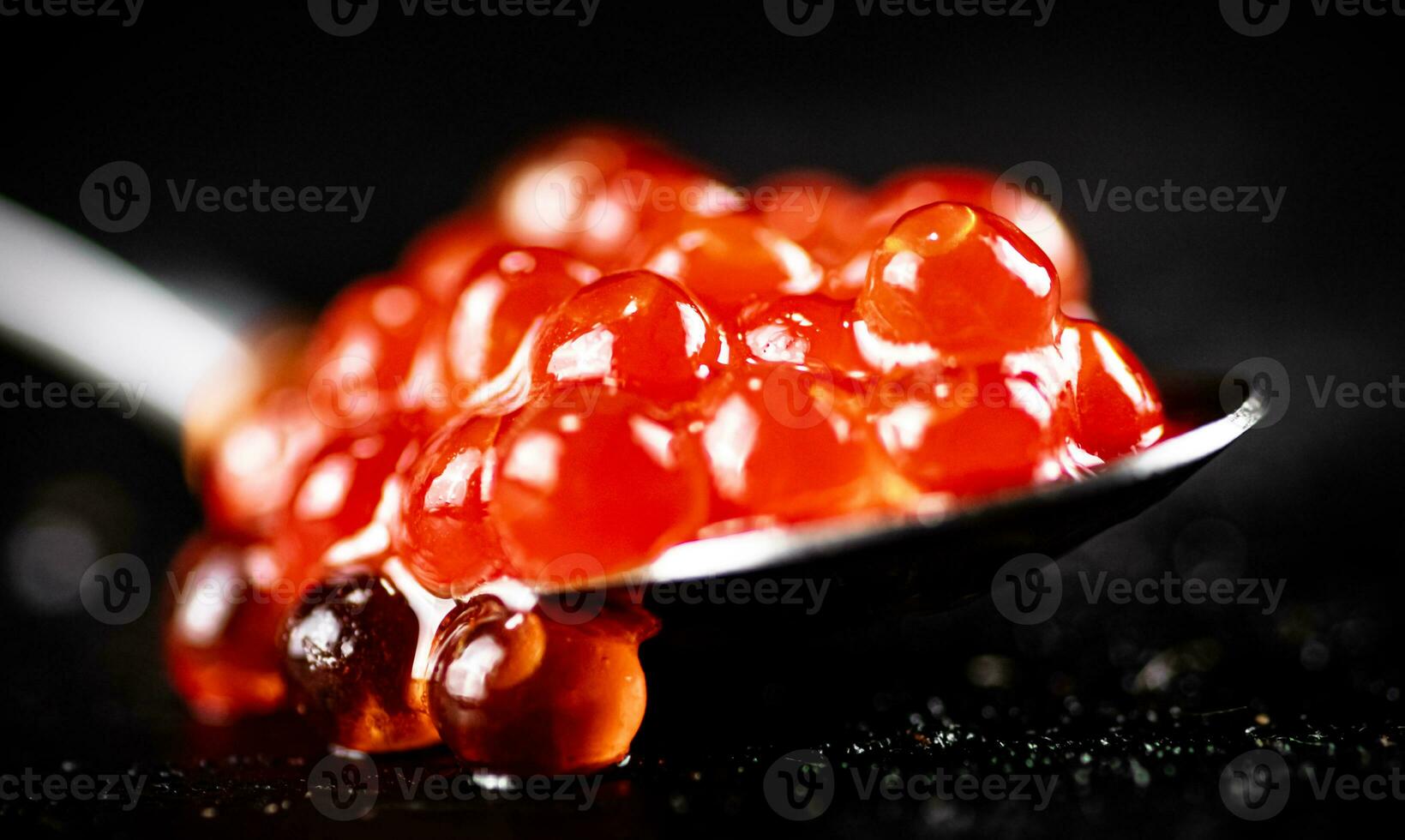 Red caviar in a spoon on the table. photo