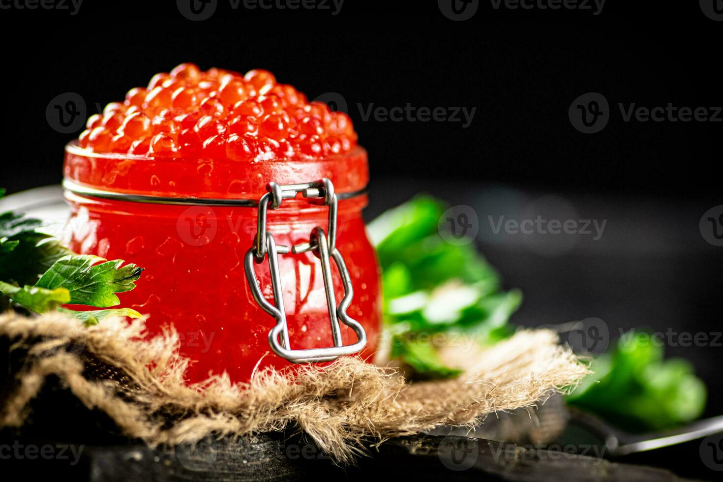 Red caviar on a cutting board with parsley. photo