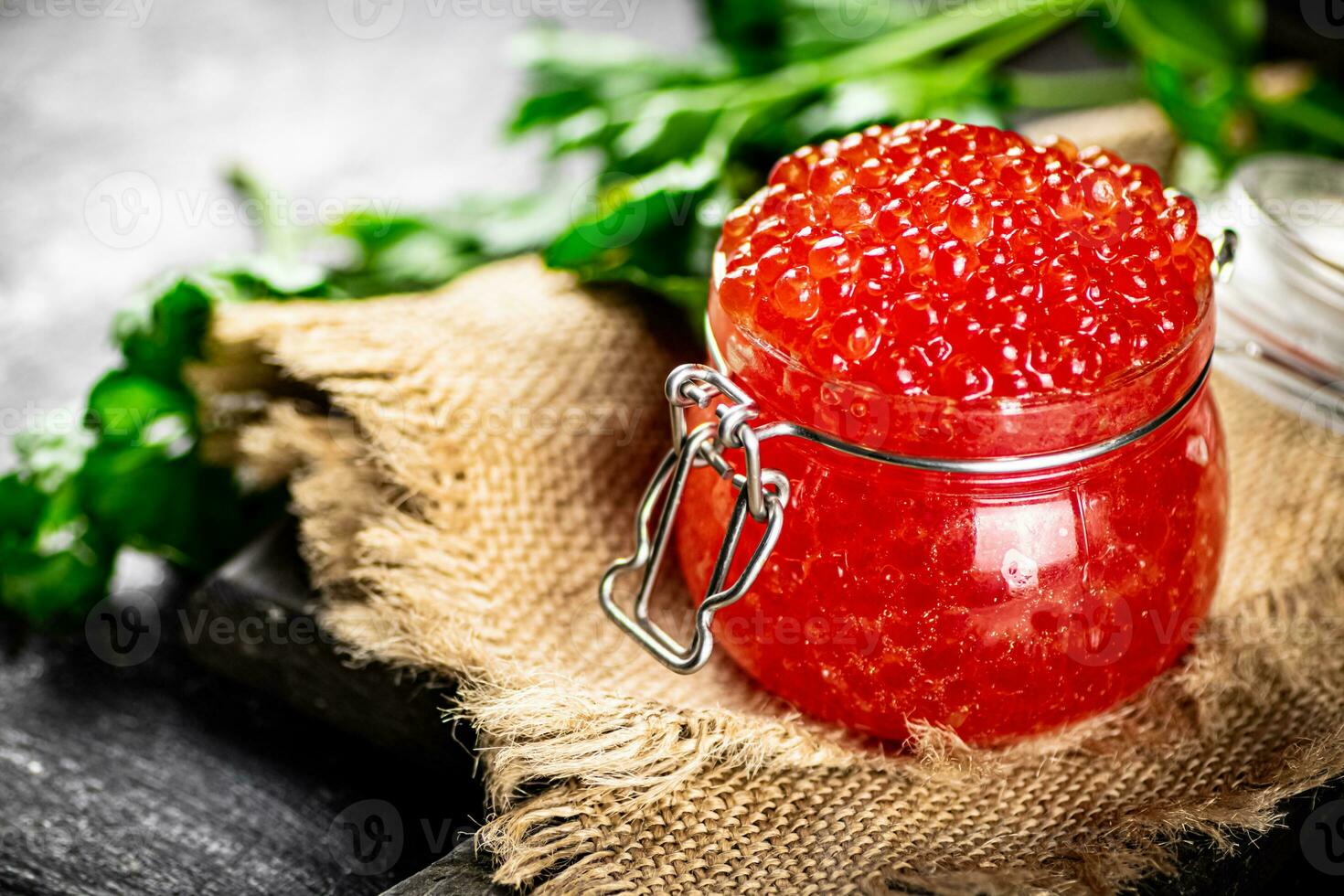 Red caviar on a cutting board with parsley. photo