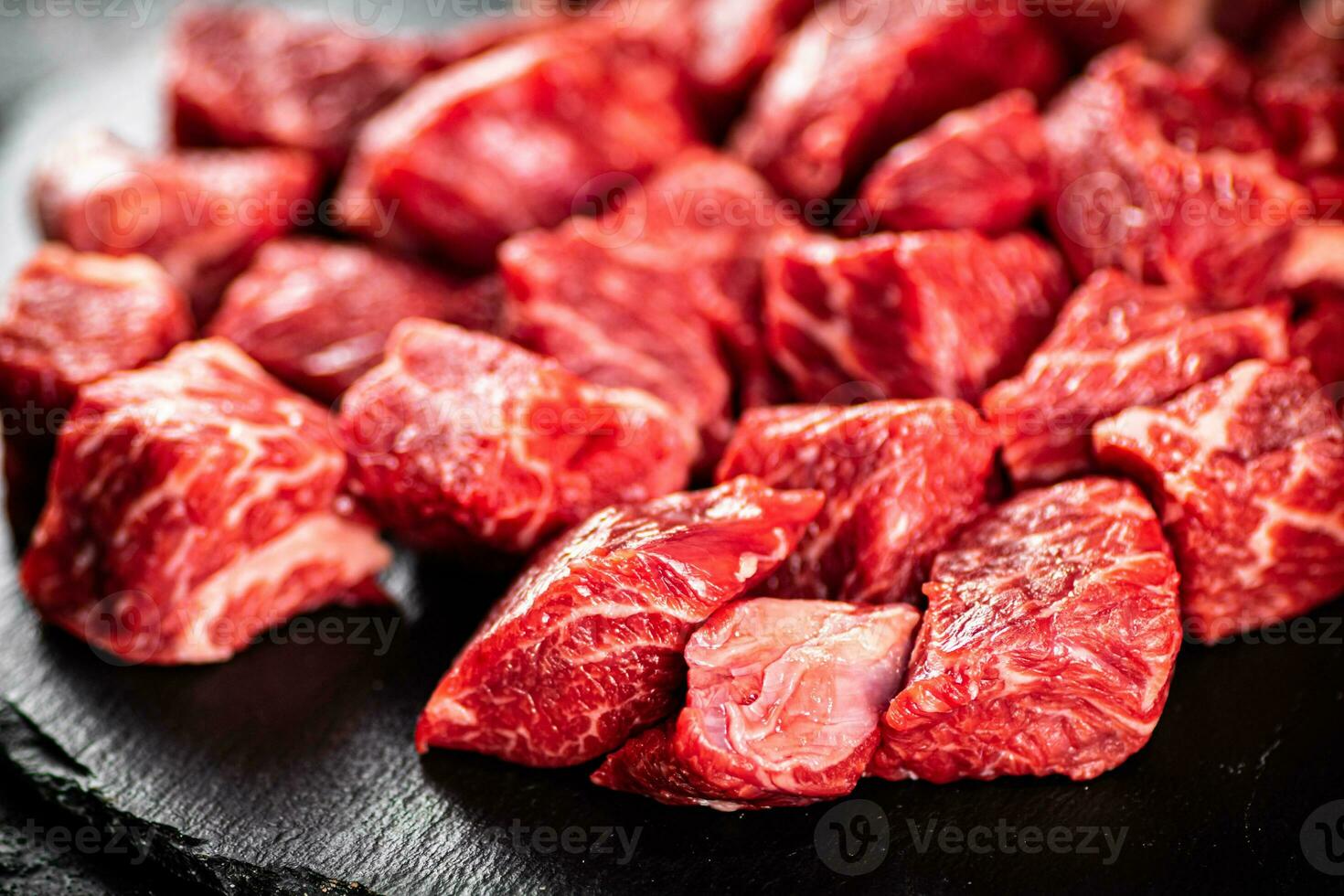 Pieces of raw beef on a stone board. photo