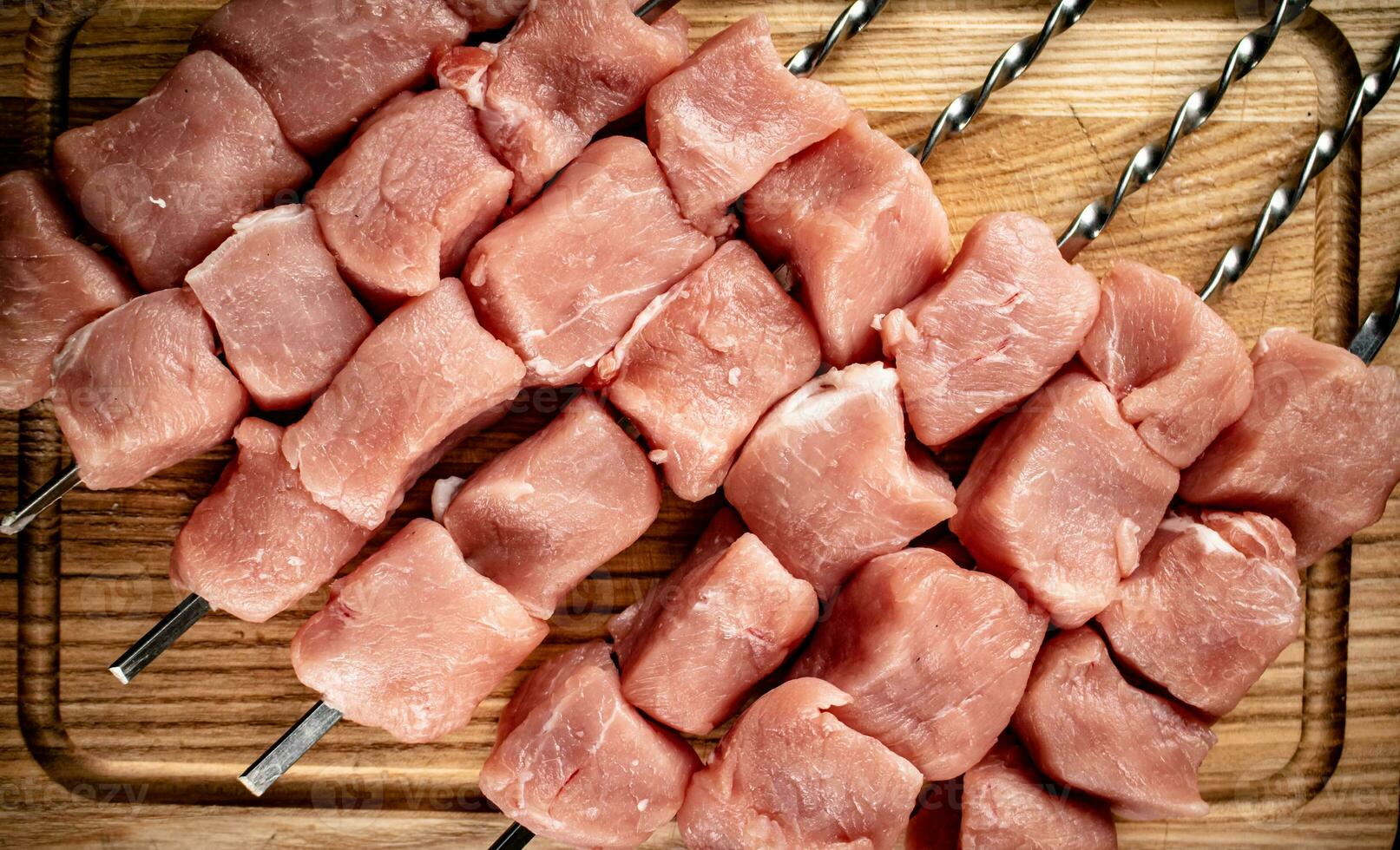Pork raw kebab on a cutting board. photo
