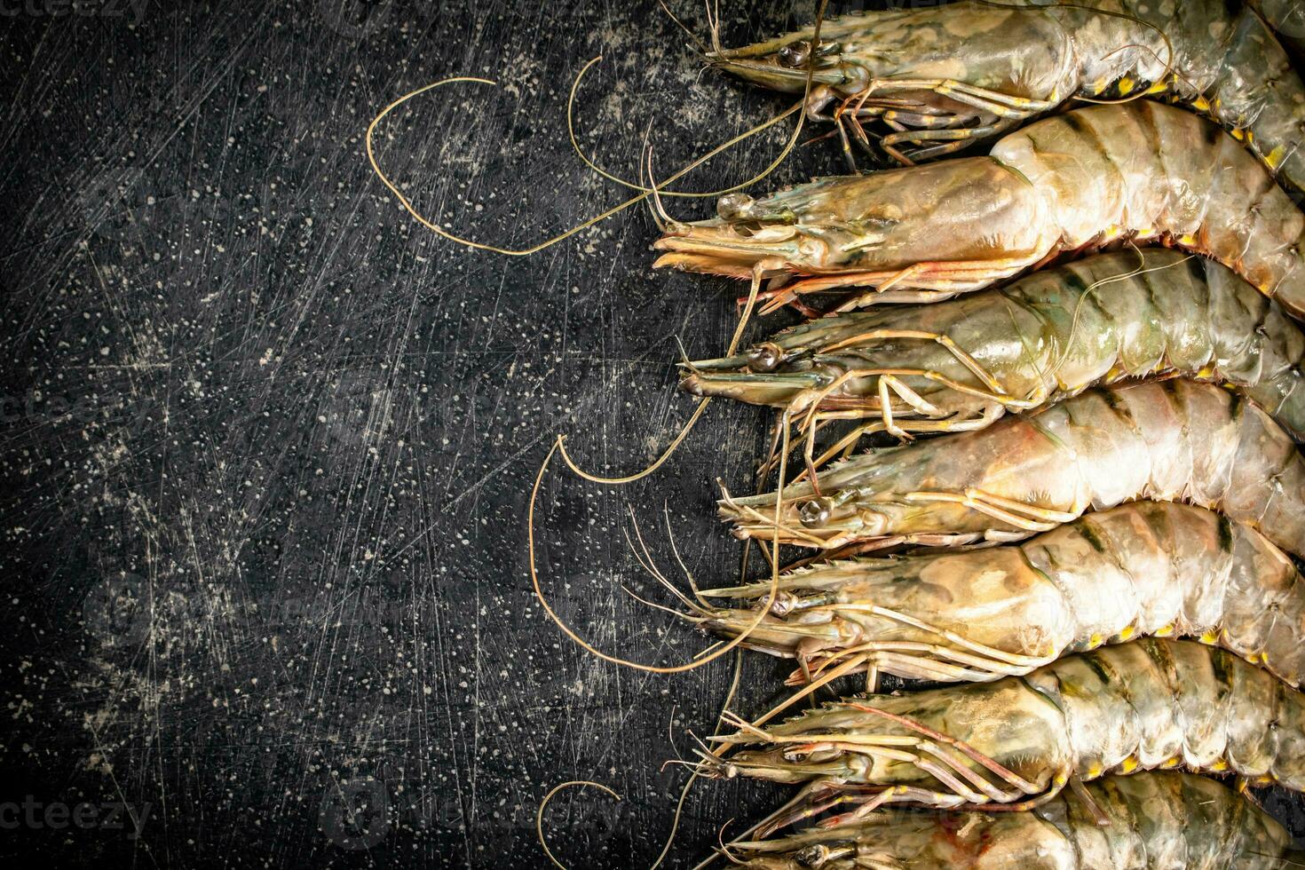 Fresh uncooked raw shrimp. On a black background. photo