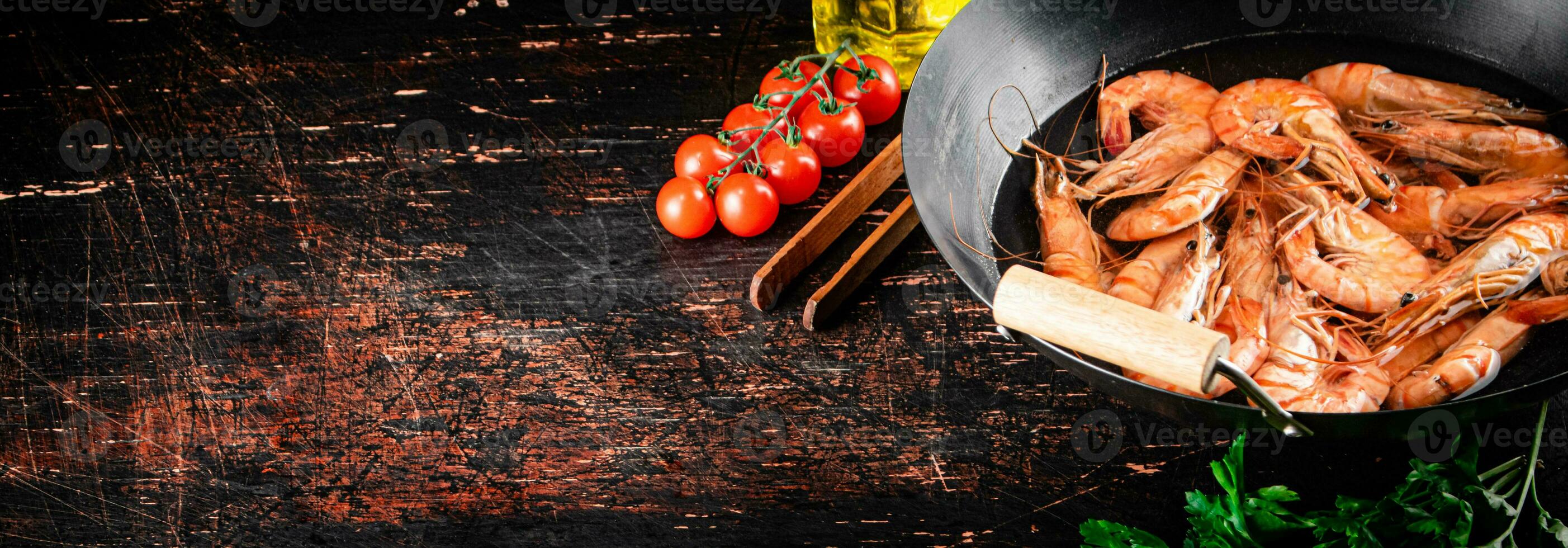 Cooked shrimp in a saucepan with parsley and tomatoes. photo