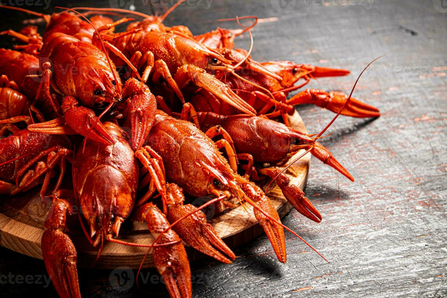 Boiled crayfish on a round cutting board. photo