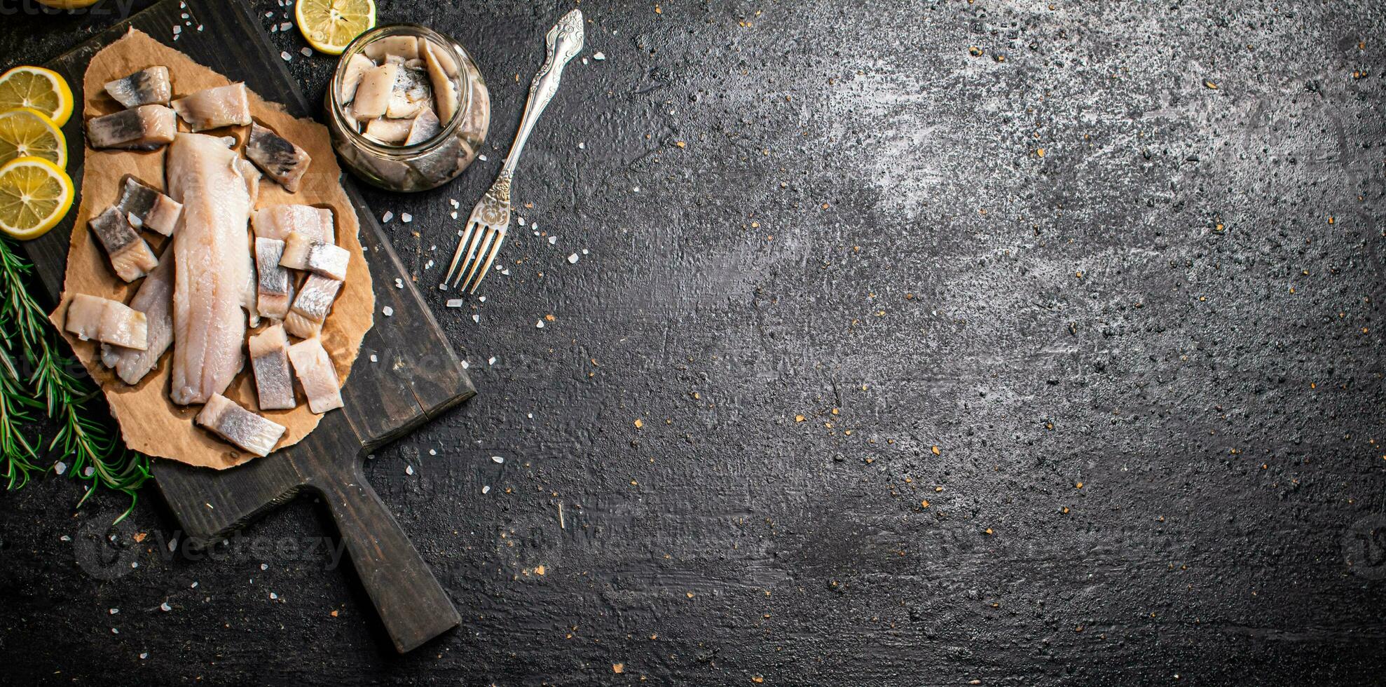 Fillet of salted herring on paper on a cutting board. photo