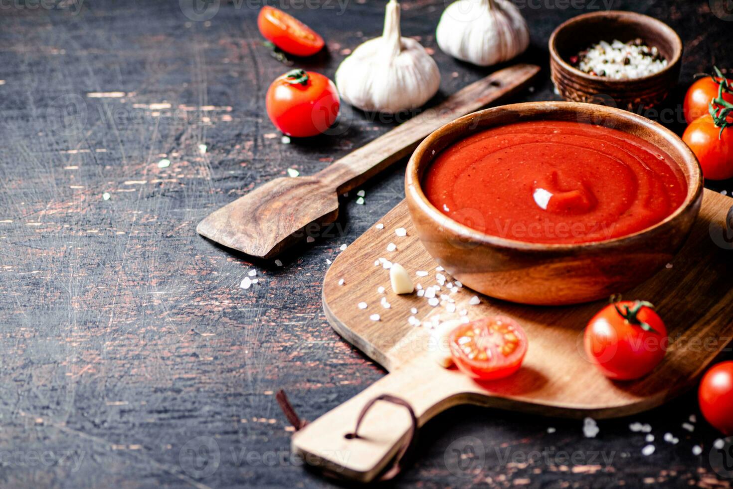 Tomato sauce on a wooden cutting board with garlic and spices. photo