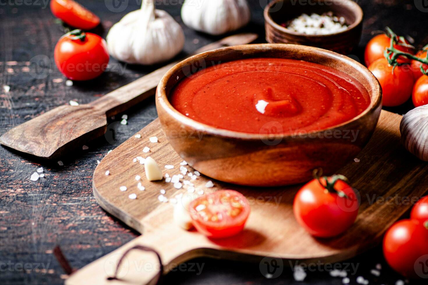 Tomato sauce on a wooden cutting board with garlic and spices. photo