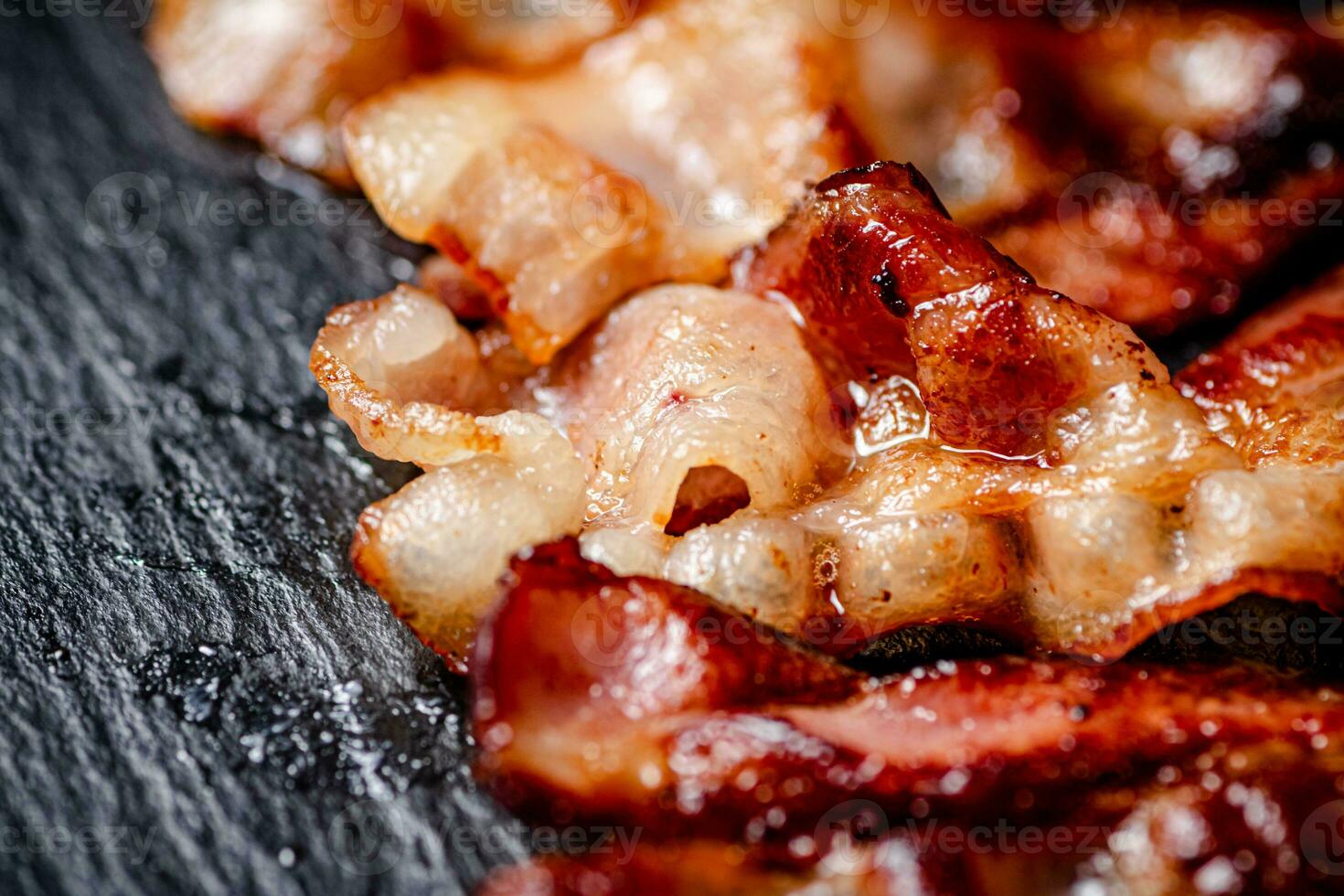 Strips of fried bacon on a black background. photo
