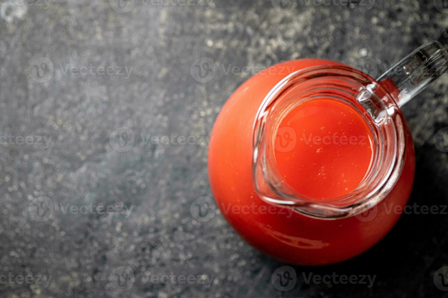 Jug with tomato juice on the table. photo