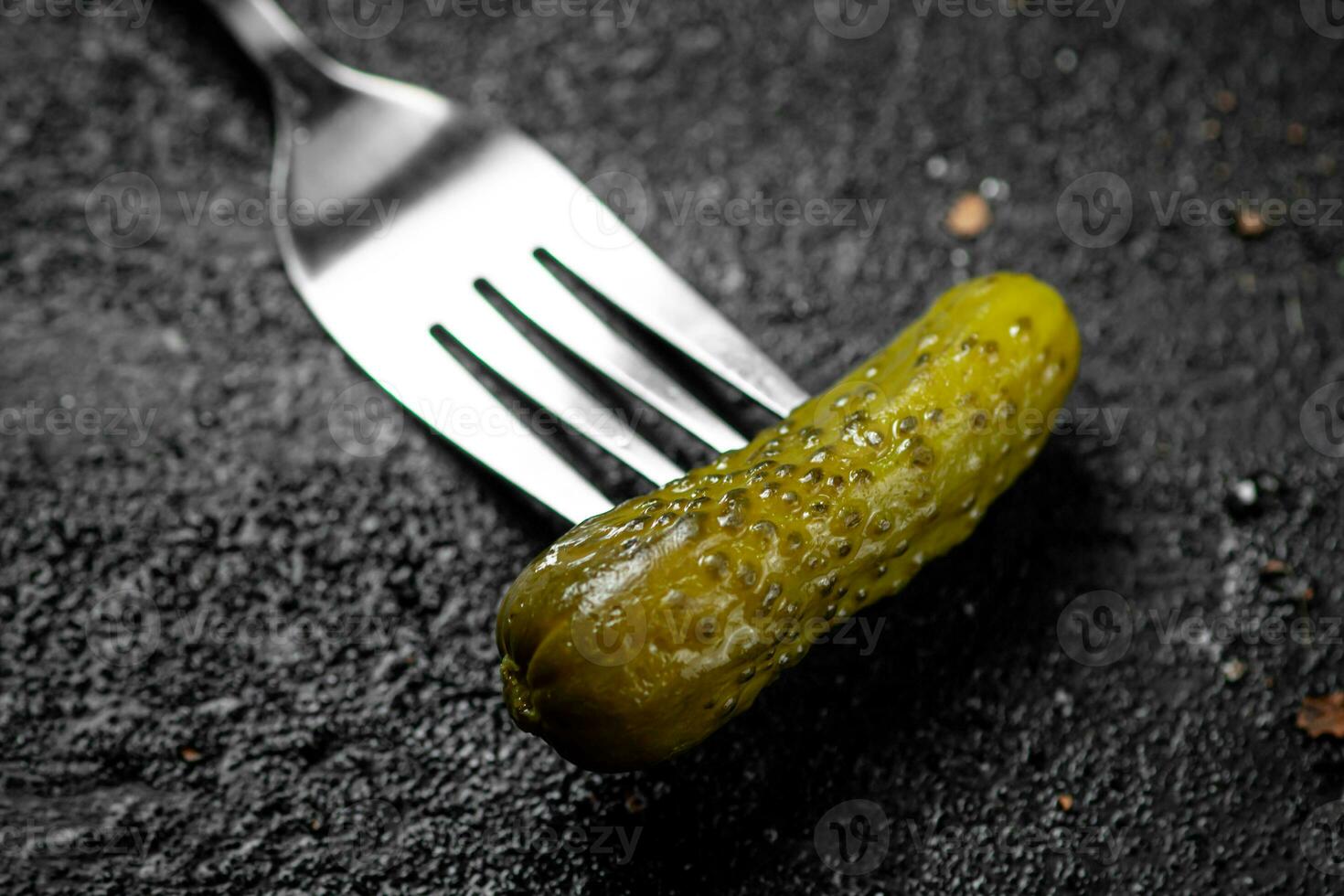 One pickled cucumber on a fork. photo