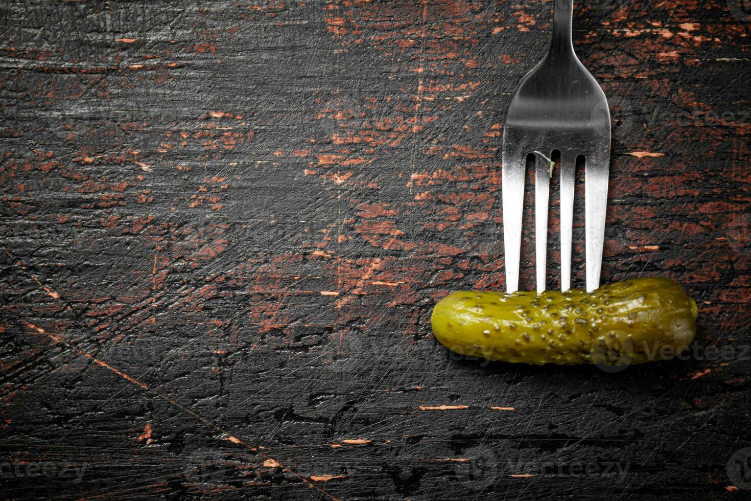One pickled cucumber on a fork. photo