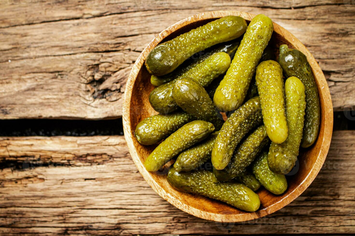 Pickled cucumbers on a wooden plate. photo