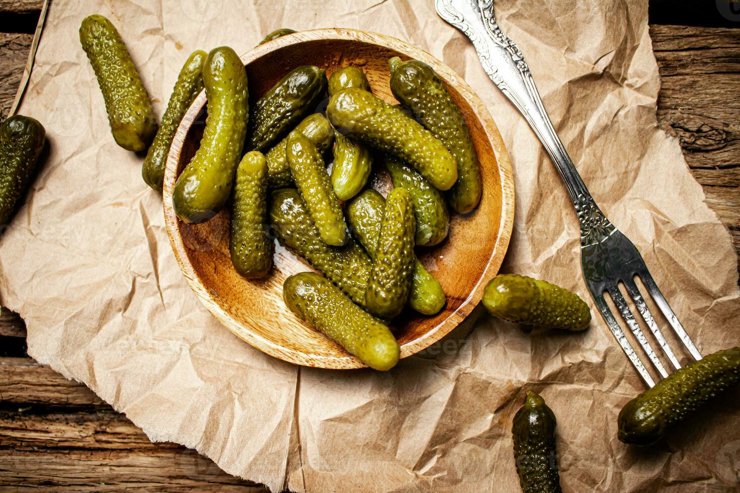 Pickled cucumbers on a wooden plate. photo