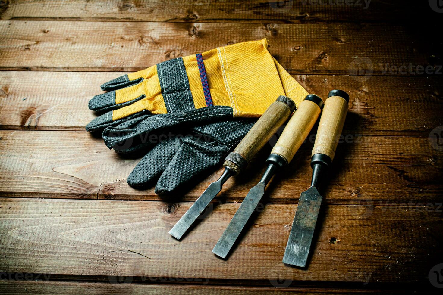 Chisel with construction gloves on the table. photo