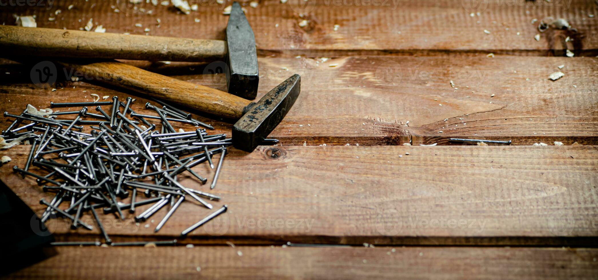 Hammer with a bunch of nails on the table. photo