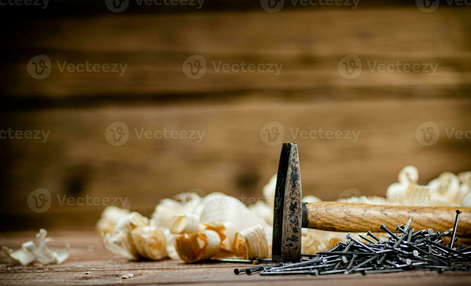 Hammer with a bunch of nails on the table. photo