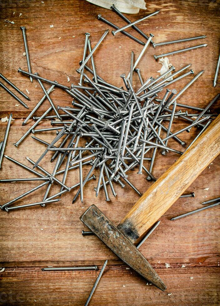 Hammer with a bunch of nails on the table. photo