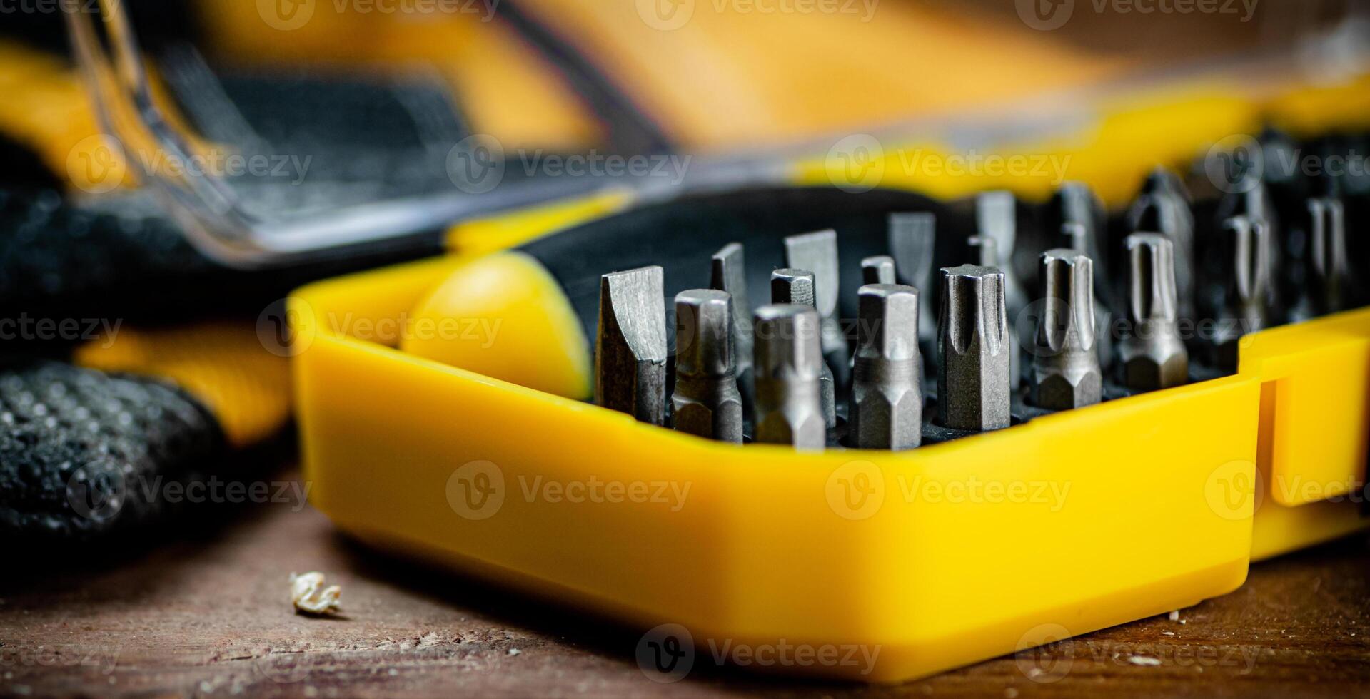 Working tools. Screwdriver bits. On a wooden background. photo