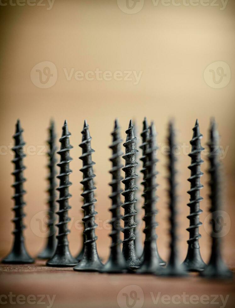 Self-tapping screw on wood on the table. photo