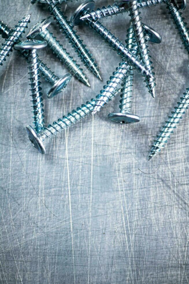 A bunch of self-tapping screws on the table. photo