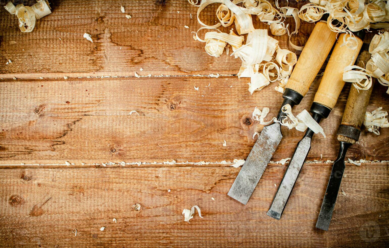 Chisels with wooden shavings. On a wooden background. photo