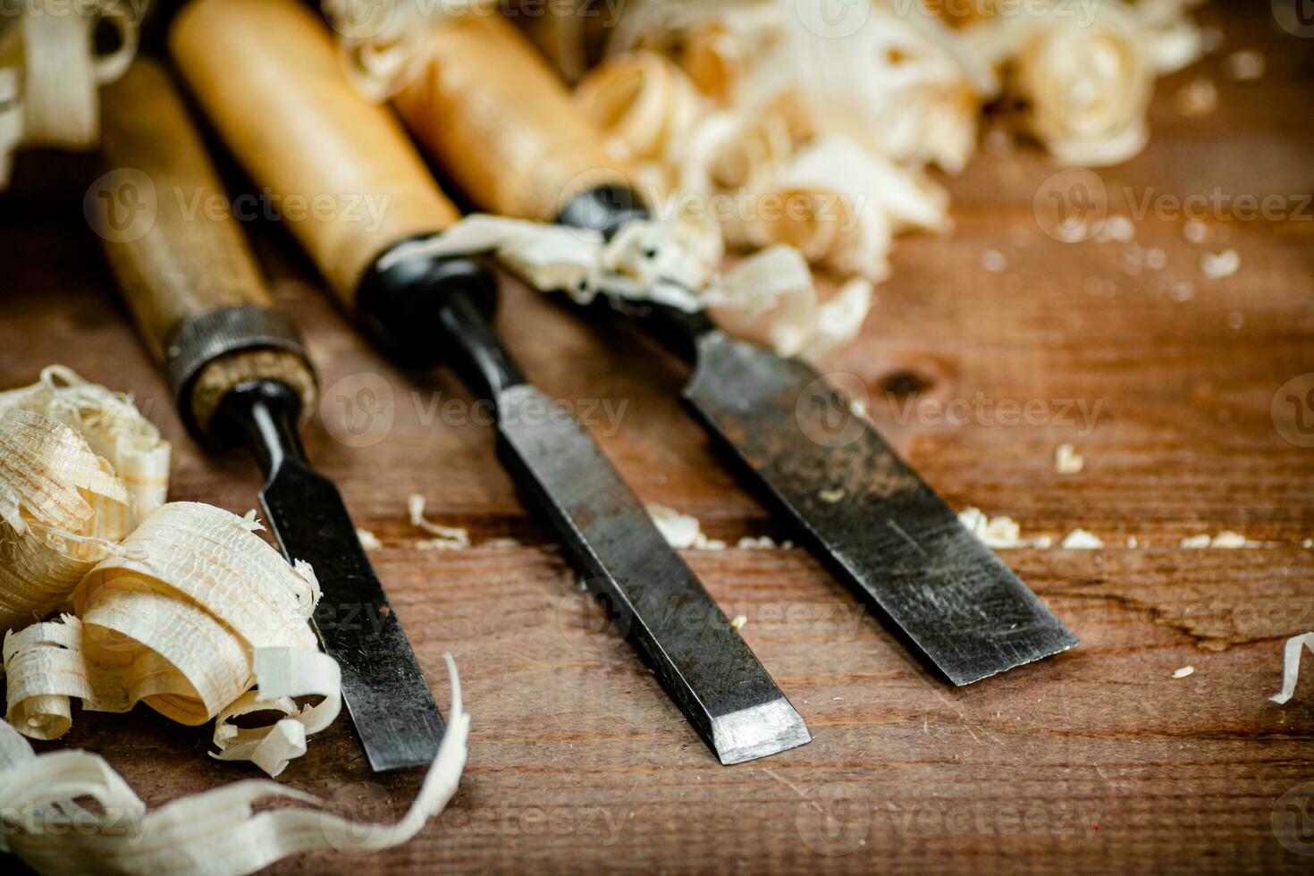 Chisels with wooden shavings. On a wooden background. photo